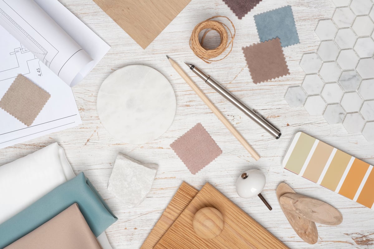 Designer's desk with material samples, tools and floor plans